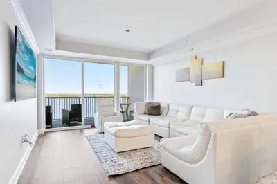 a living room with white furniture and a large window at Lake Views At Blue Heron in Orlando