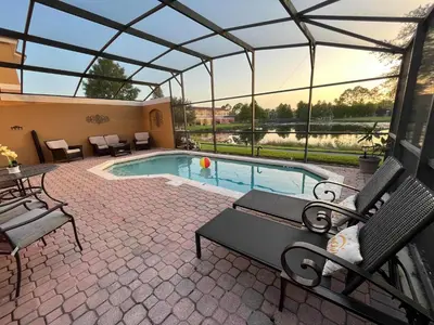 a patio with a swimming pool with a glass roof at Create Lasting Magical Memories Resort Home for 8 in Kissimmee