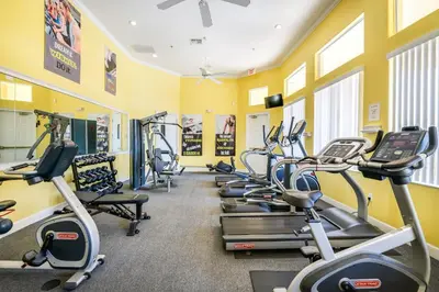 a row of exercise bikes in a gym with yellow walls at Create Lasting Magical Memories Resort Home for 8 in Kissimmee