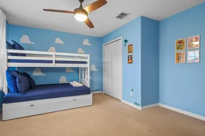 a blue bedroom with a bunk bed and a ceiling fan at Main Street Gem in Paradise Palms Resort in Kissimmee