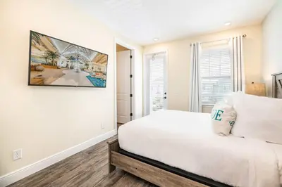 a bedroom with a white bed and a painting on the wall at The Sea Shelter - Sunny 4 BDR in Margaritaville in Orlando