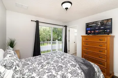 a bedroom with a bed and a dresser and a window at The Emerald Cove - Best Spot in Kissimmee in Kissimmee