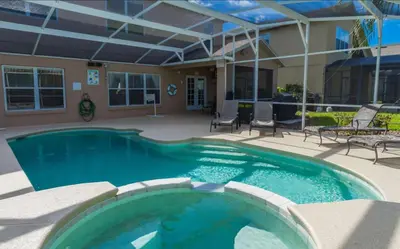 a swimming pool in a patio with chairs and a house at Marcellas Villa At Acadia Estates in Orlando