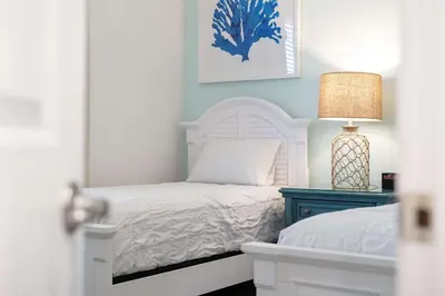a bedroom with a white bed and a blue nightstand at Mint to Be in Orlando