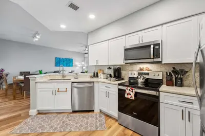 a kitchen with white cabinets and a stove top oven at Minutes to Magic in Orlando