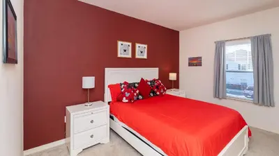 a bedroom with a red bed and a window at Moana's Hut - Miles from World's Best Theme Parks in Kissimmee
