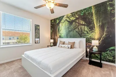 a bedroom with a large bed with a painting on the wall at Once Upon a Stay in Kissimmee