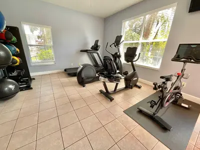 a gym with several exercise equipment in a room at Once Upon a Stay in Kissimmee