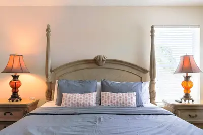 a bedroom with a bed with pillows and two lamps at New Ownership - 7BR - close to Disney in Orlando
