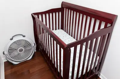 a baby crib with a fan next to a wall at New Ownership - 7BR - close to Disney in Orlando