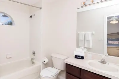 a white bathroom with a toilet and a sink at New Ownership - 7BR - close to Disney in Orlando