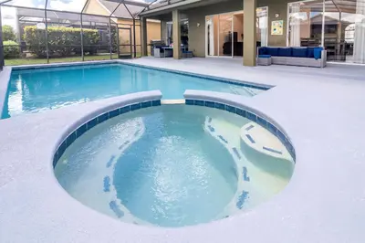 a swimming pool with blue water in the middle at New Ownership - 7BR - close to Disney in Orlando