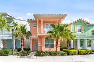 a row of houses with palm trees in front at Parrot Paradise Escape for 8 in Orlando