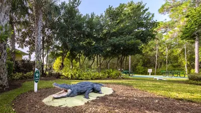 a statue of a crocodile on a rock in a park at Peaceful Horizons at Caribe Cove in Kissimmee