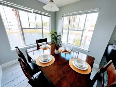 a dining room with a wooden table and chairs at Playing Hooky in Kissimmee