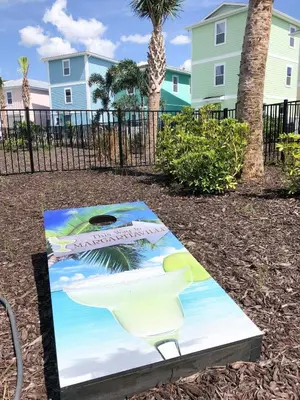 a painting on a table in a park with palm trees at Rum Runners and Margaritas in Orlando