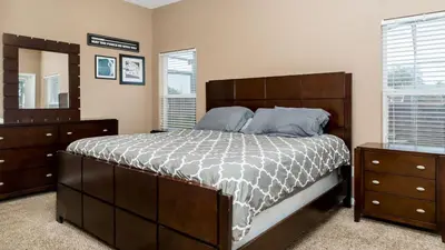 a bedroom with a large bed and two dressers at Serendipity at Acadia - Family getaway in Orlando