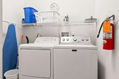 a small laundry room with a white washer at Slice Of Sunshine At Caribe Cove in Kissimmee