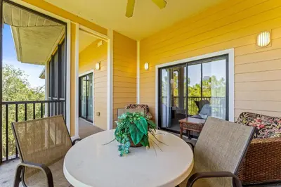a patio with a table and chairs on a porch at Slice Of Sunshine At Caribe Cove in Kissimmee