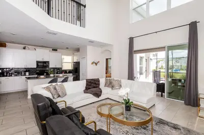 a living room with a white couch and a table at Storeybook Escape - Sleeps 11 in Kissimmee