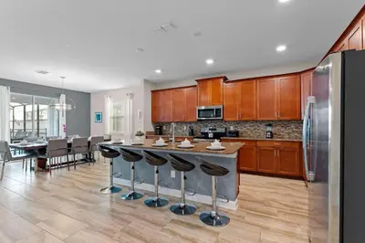 a kitchen with a large island with bar stools at Sun & Fun Storey Lake in Kissimmee