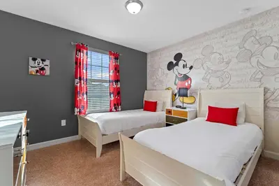 a bedroom with two beds and a wall with a mickey mouse mural at Sun & Fun Storey Lake in Kissimmee