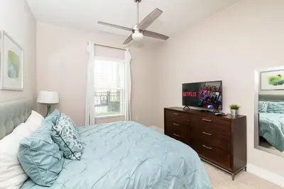 a bedroom with a bed and a ceiling fan at Sunrise in Kissimmee - Near Disney World in Orlando