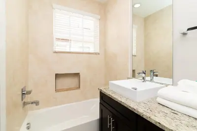 a bathroom with a sink and a bath tub and a sink at Sunrise in Kissimmee - Near Disney World in Orlando