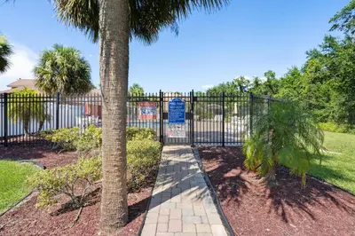 a wrought iron gate with a palm tree in a yard at 2466 Sweetwater in Kissimmee