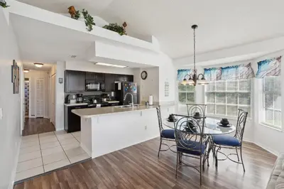 a kitchen and dining room with a table and chairs at 2466 Sweetwater in Kissimmee