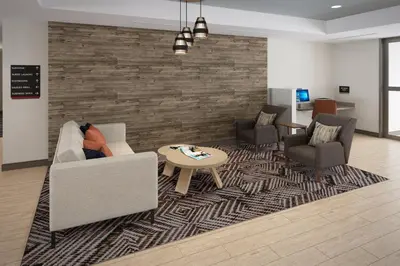 a living room with two chairs and a table on a rug at Candlewood Suites Orlando North - Winter Park by IHG in Orlando