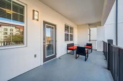 a balcony with chairs and a table and windows at Conforto e Estilo | 3Q Piscina & Resort in Orlando