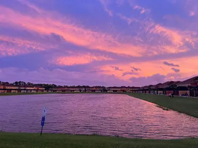 a large body of water with a sunset in the background at Fully Equipped Comfortable Townhouse in Kissimmee