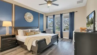 a bedroom with a large bed with a blue wall at Disney Retreat w/ Wizard & Galaxy Rooms in Orlando