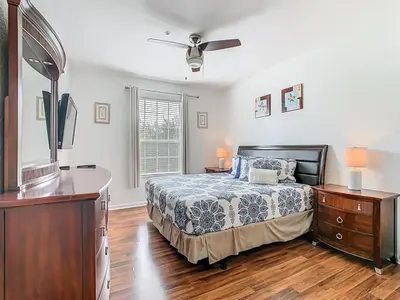 a bedroom with a bed and a dresser and a tv at Windsor Hills Modern 3BR Condo with Resort Amenities in Orlando