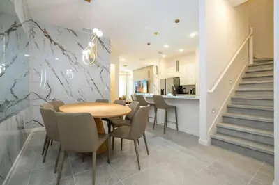 a dining room with a table and chairs and stairs at Paradiso Grande 5 Bed New Townhome - 10329 in Orlando