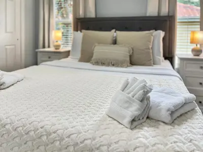 a white bed with towels on top of it at Rumi Haven-Homey&Spacious Stay in Orlando