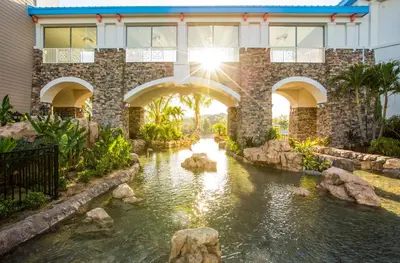 a house with a pond in front of a building at Universal's Loews Sapphire Falls Resort in Orlando