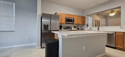 a kitchen with a stainless steel refrigerator and wooden cabinets at SHVPC3 - Paradise Cay #3 - 3 Bed 2.5 Baths Townhome in Kissimmee