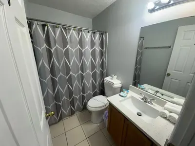 a bathroom with a toilet and a sink and a mirror at SHVPC3 - Paradise Cay #3 - 3 Bed 2.5 Baths Townhome in Kissimmee