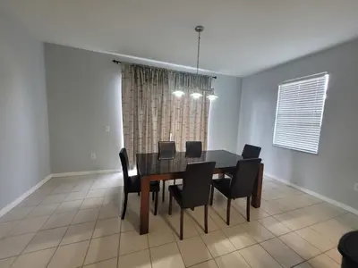 a dining room with a black table and chairs at SHVPC3 - Paradise Cay #3 - 3 Bed 2.5 Baths Townhome in Kissimmee
