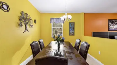 a dining room with yellow walls and a table and chairs at SHVCC1 - Crystal Cove #1 - 7 Bed 4.5 Baths Villa in Kissimmee