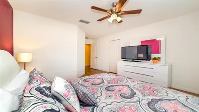 a bedroom with a bed and a flat screen tv at SHVCC1 - Crystal Cove #1 - 7 Bed 4.5 Baths Villa in Kissimmee