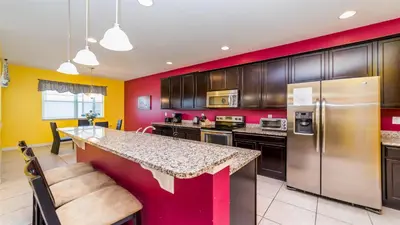 a kitchen with red and yellow walls at SHVCC1 - Crystal Cove #1 - 7 Bed 4.5 Baths Villa in Kissimmee