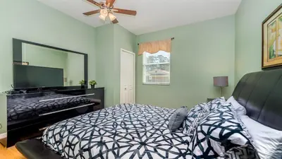 a bedroom with a bed and a mirror and a piano at SHVCC1 - Crystal Cove #1 - 7 Bed 4.5 Baths Villa in Kissimmee