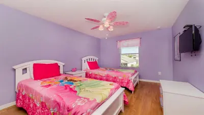 two beds in a purple room with a ceiling fan at SHVCC2 - Crystal Cove #2 - 7 Bed 4.5 Baths Villa in Kissimmee
