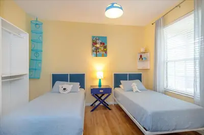 a bedroom with two beds and a table with a lamp at Peaceful Getaway in Windsor Hills in Orlando