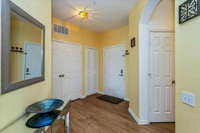 a hallway with two white doors and a mirror at Peaceful Getaway in Windsor Hills in Orlando