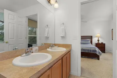 a bathroom with two sinks and a large mirror at Spacious Lakefront Townhouse 10 Mins To Disney in Kissimmee