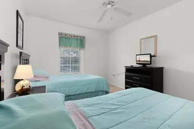 a bedroom with two beds and a television in it at Spacious Lakefront Townhouse 10 Mins To Disney in Kissimmee